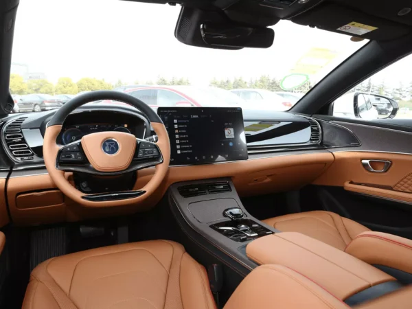 A picture of a BYD Han front steering wheel and a dash with a brown and black interior.