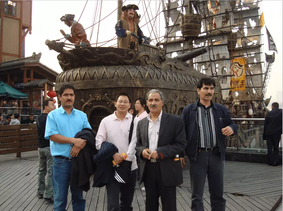 A group photo with our clients in front of a boat, all smiling.