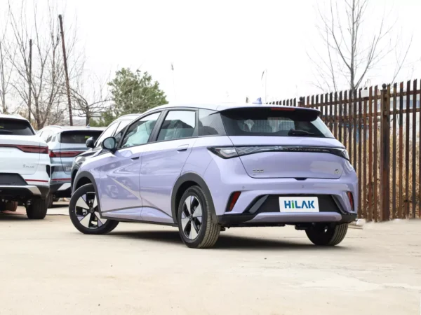 A close-up view of the left rear of a lavender BYD Dolphin electric car, with the vehicle parked in a parking lot.