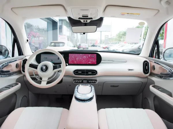 A detailed image of the interior cab of an Ora Ballet Cat electric car, with particularly lovely pink and white trim colors.