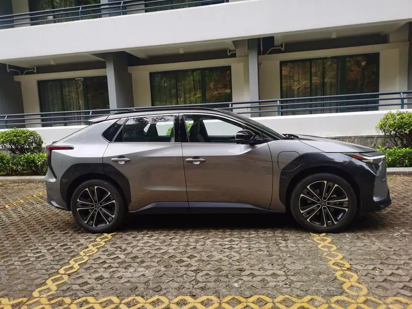 The side view of a silver Toyata BZ4X electric car parked in a parking space