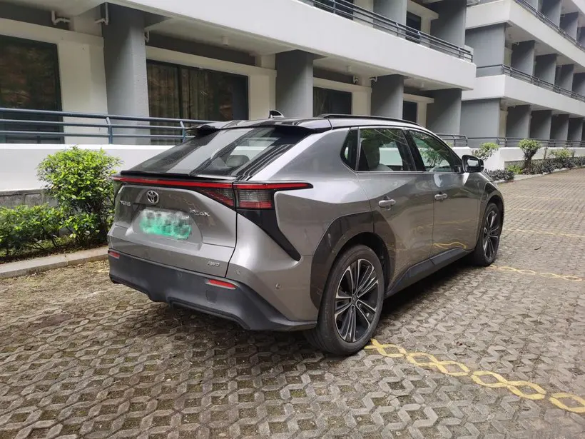 The rear side of a silver Toyota BZ4X electric car parked in a parking space