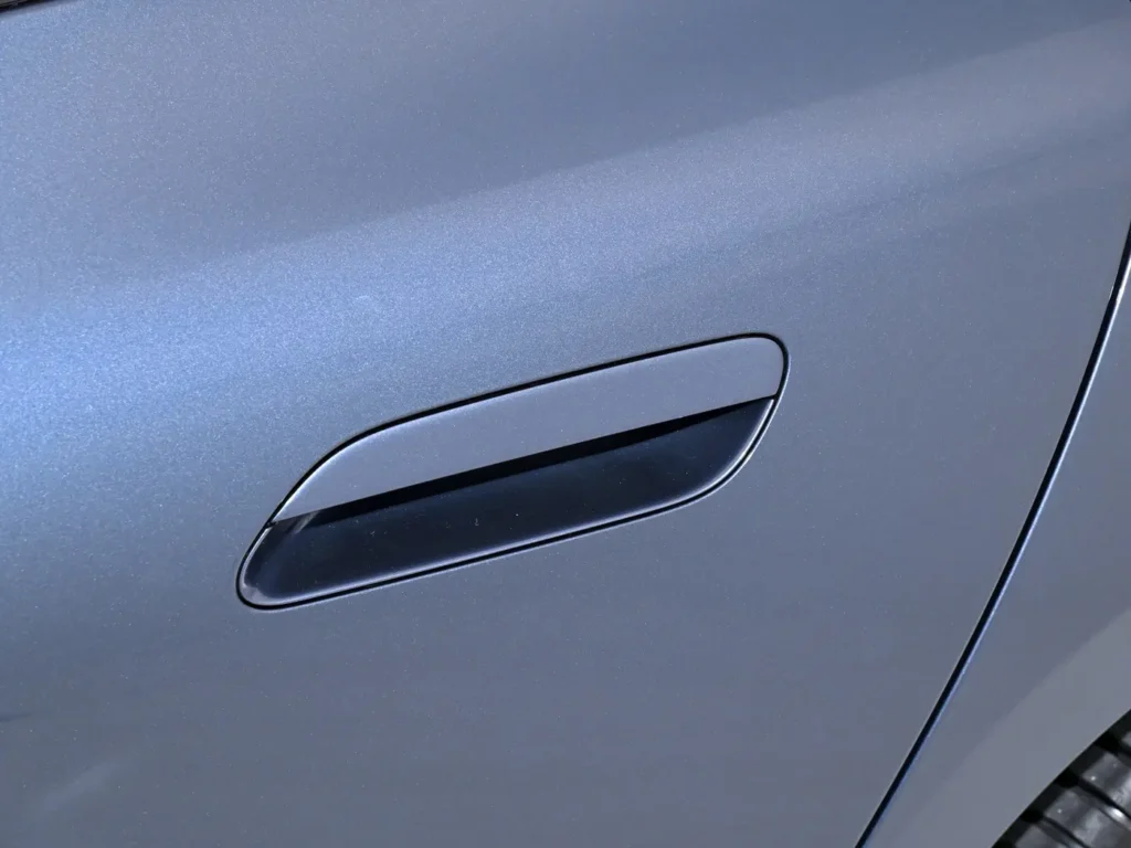 A semi-hidden handle of a dark-grey Xiaomi SU7 electric car